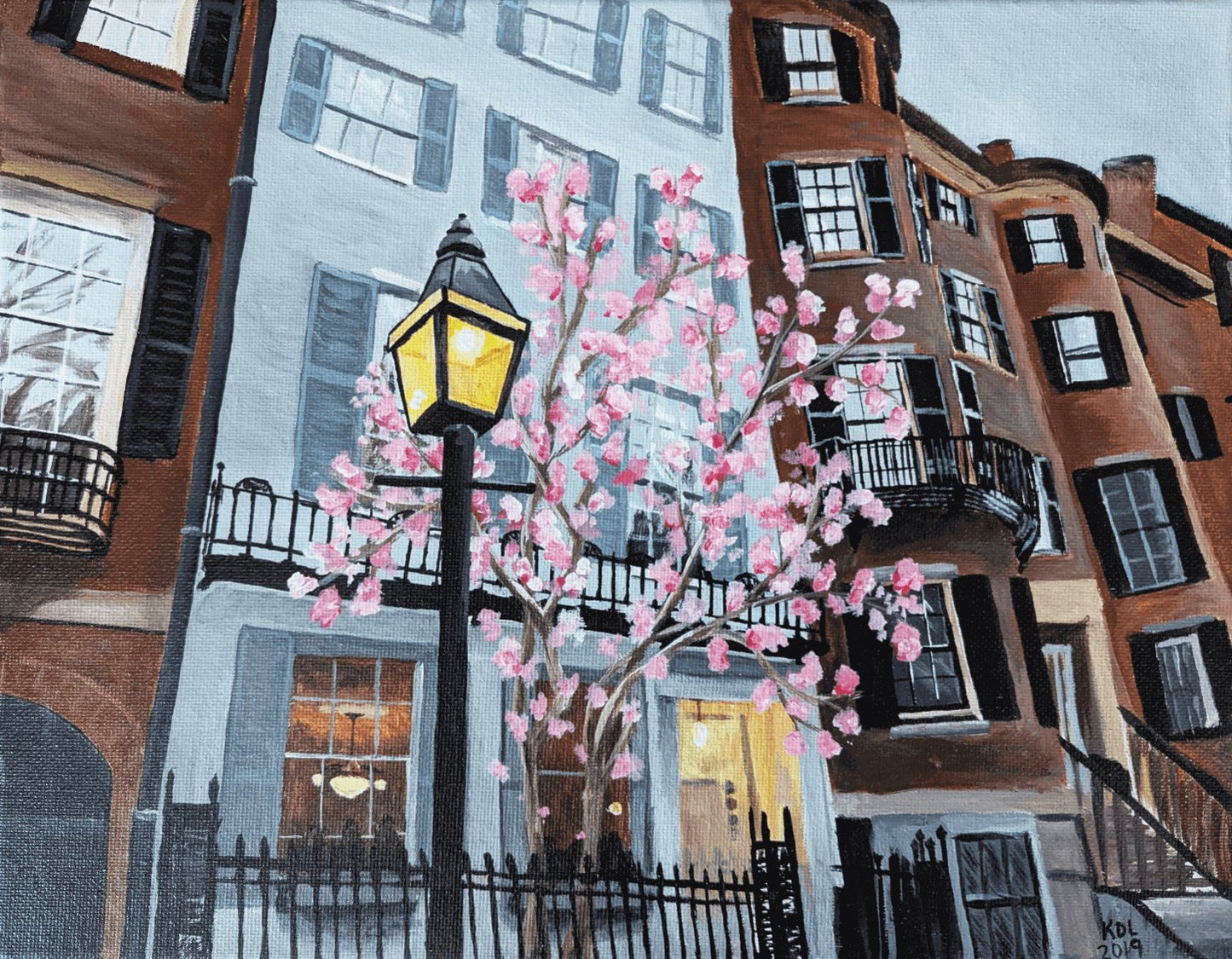 Acrylic painting of back bay in boston in the spring. There is a flowering tree in front of a grey row house with a lit lamp post